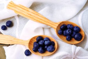 Fresh blueberries in spoons on table close up-shutterstock_338308235